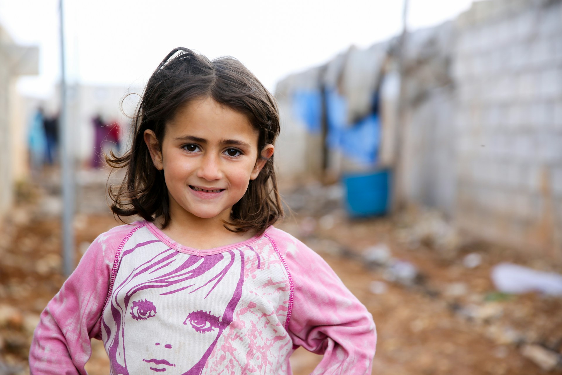 A little girl standing in a dirty alley