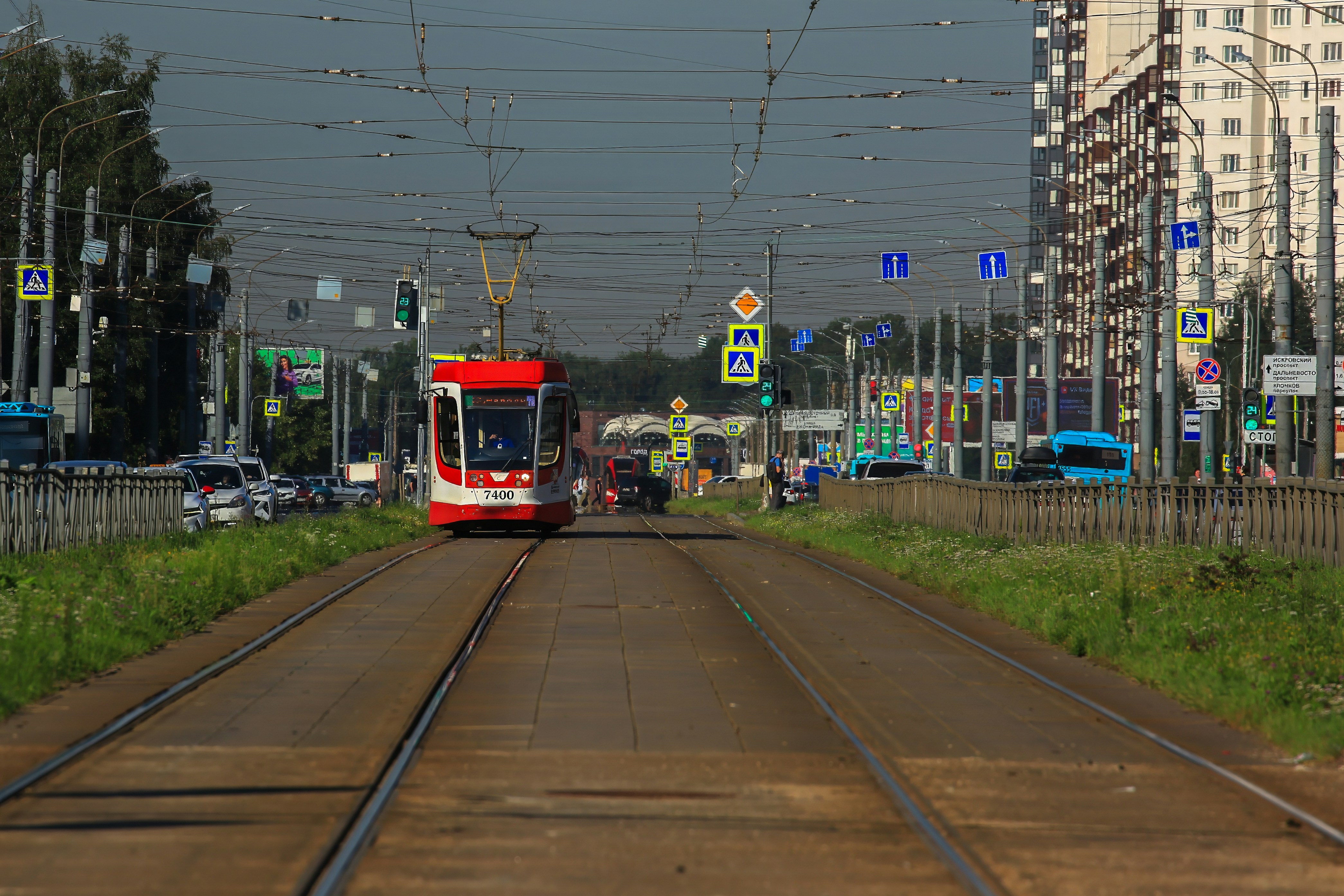 Un train rouge circulant sur les voies ferrées à côté de grands immeubles