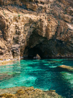 A large cave with a blue pool in the middle of it