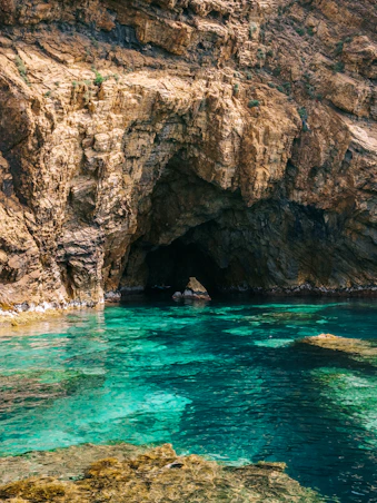 A large cave with a blue pool in the middle of it