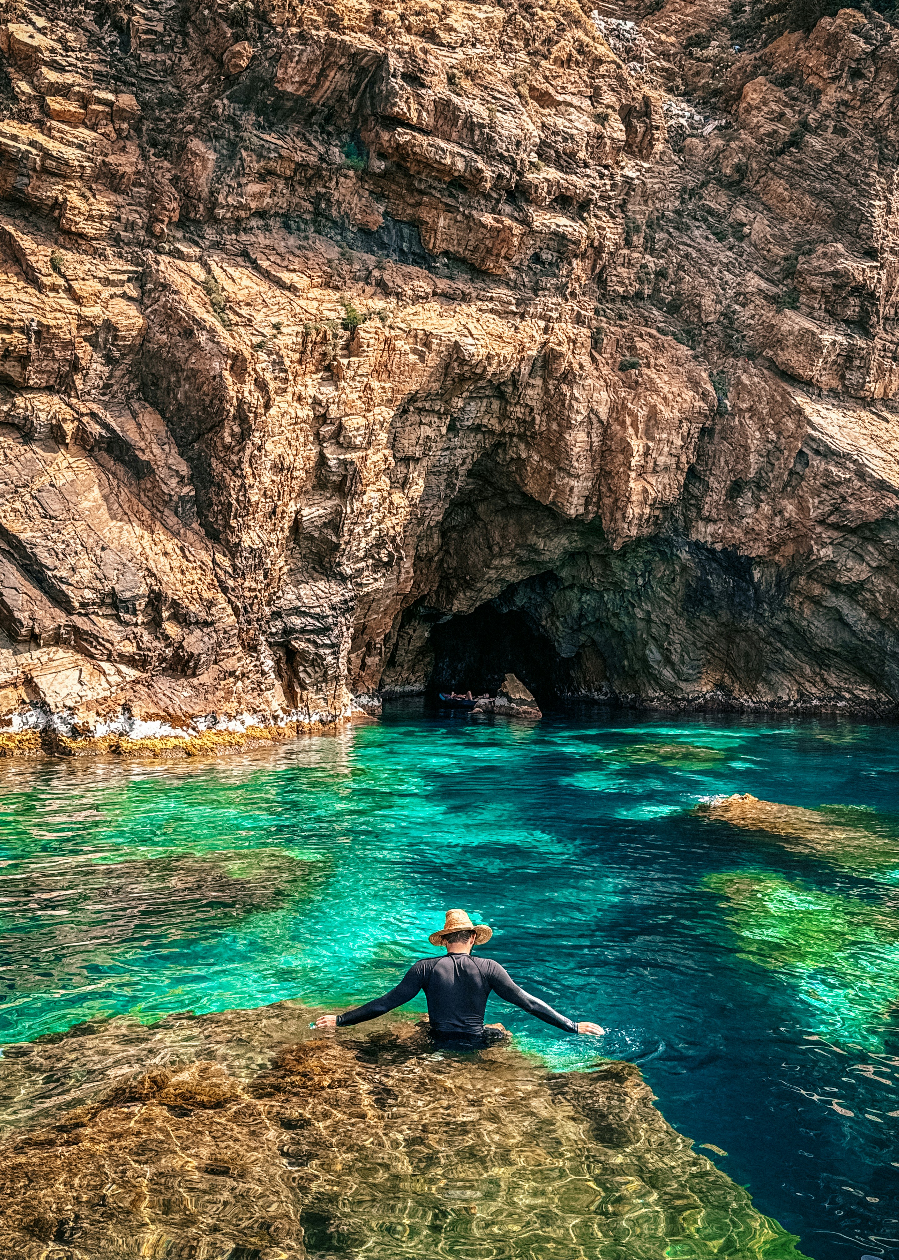 A person sitting on a rock near a body of water
