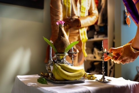 A man and a woman cutting a banana on a table