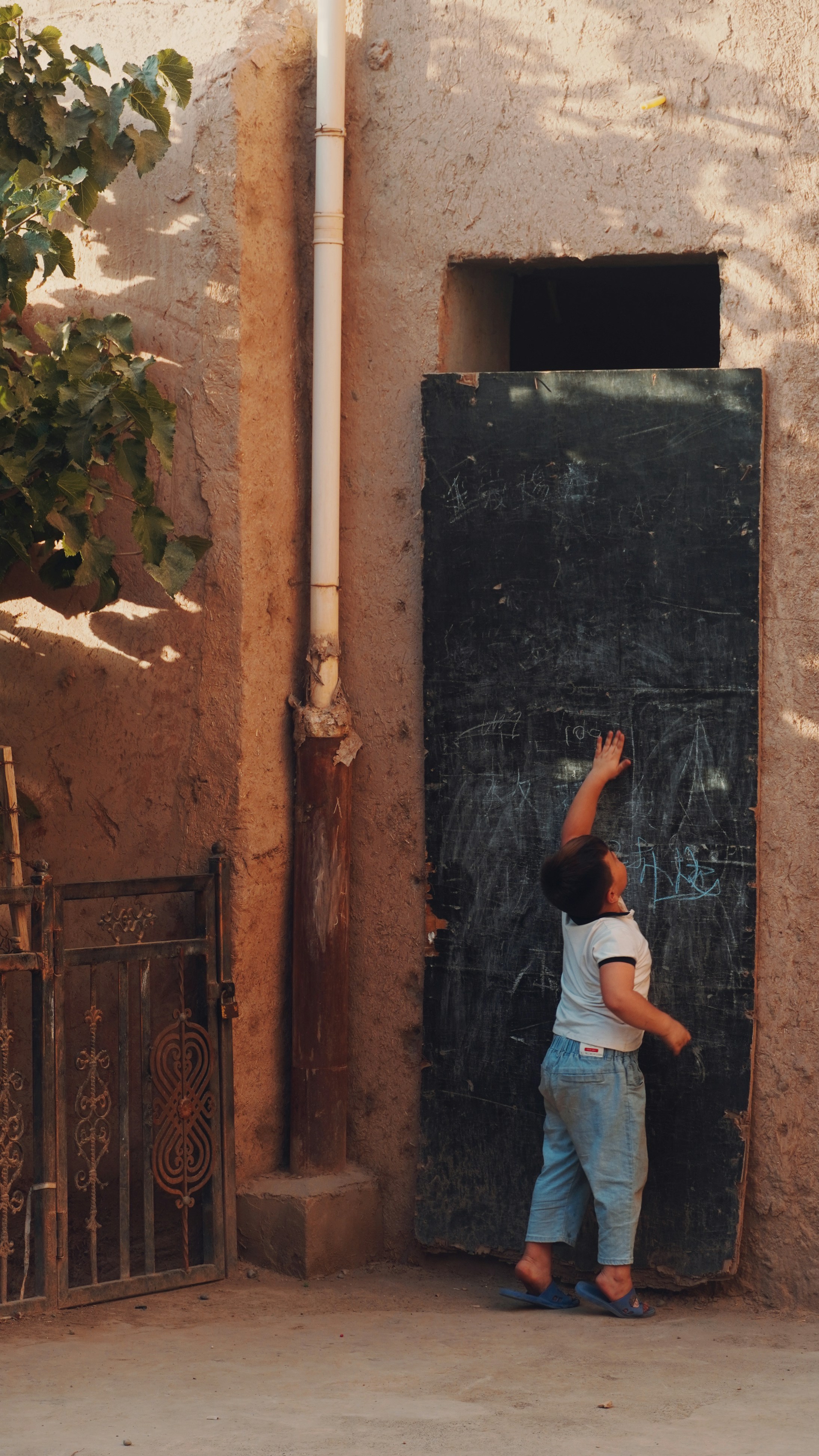 A little boy that is standing in front of a door