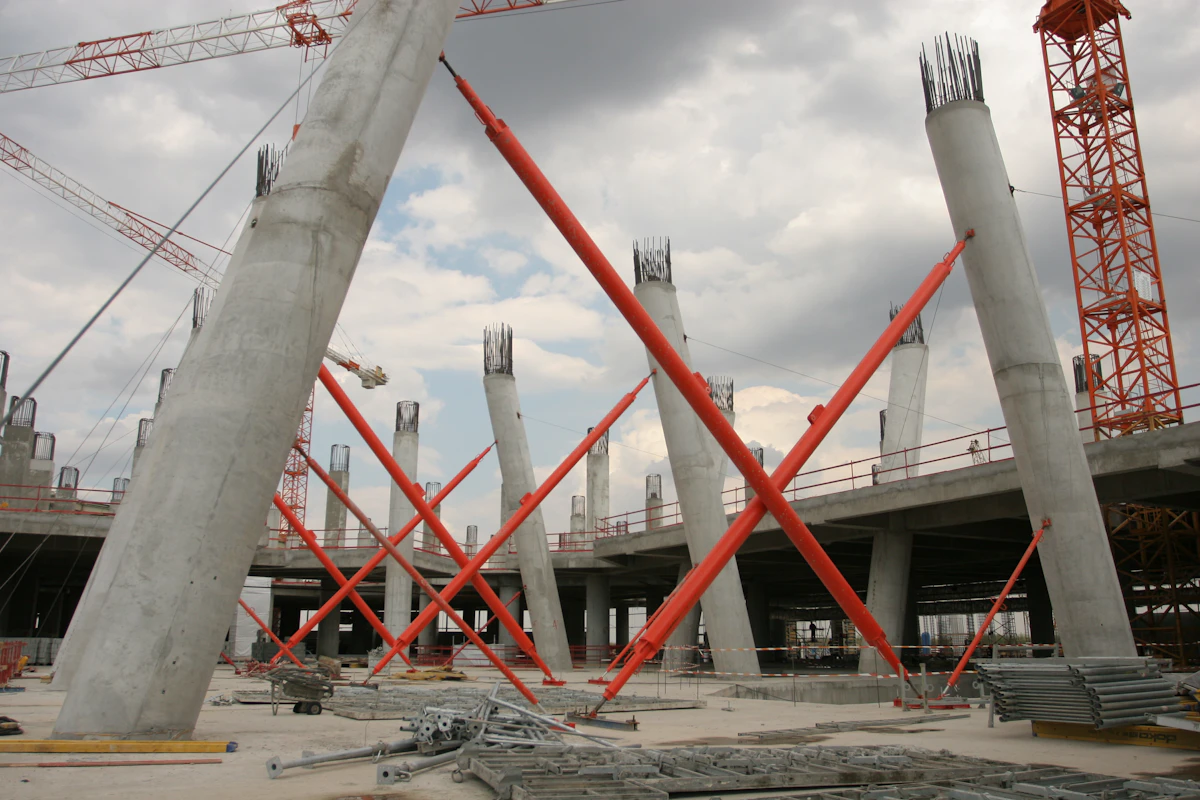 Industrial construction site with red crane lifting structural steel — building-type risk profile depends on geometry