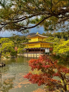 A yellow building in the middle of a pond