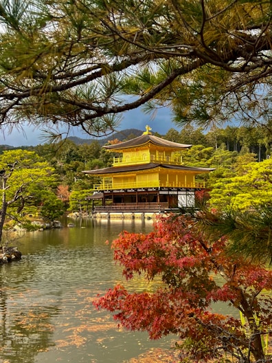 A yellow building in the middle of a pond