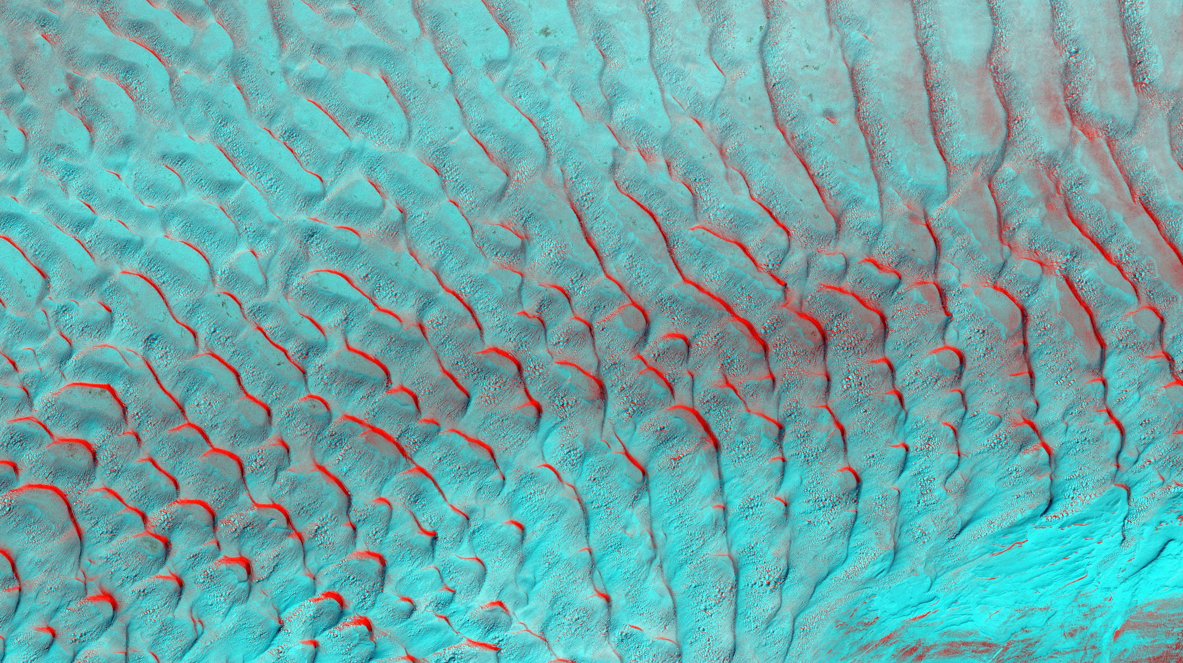 Textured sand dunes with red and blue hues (Photo by USGS on Unsplash)