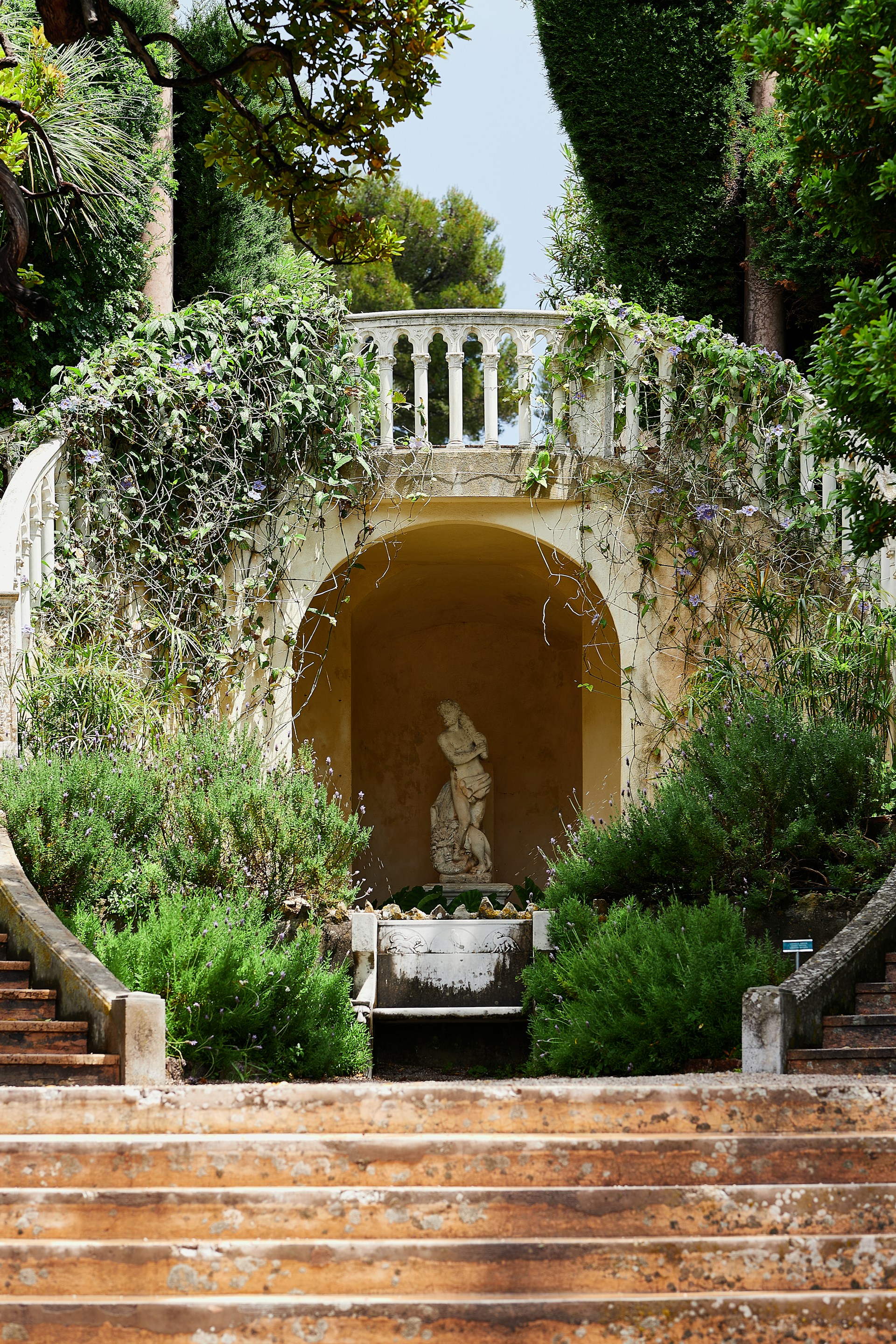 A staircase leading up to a statue in a garden
