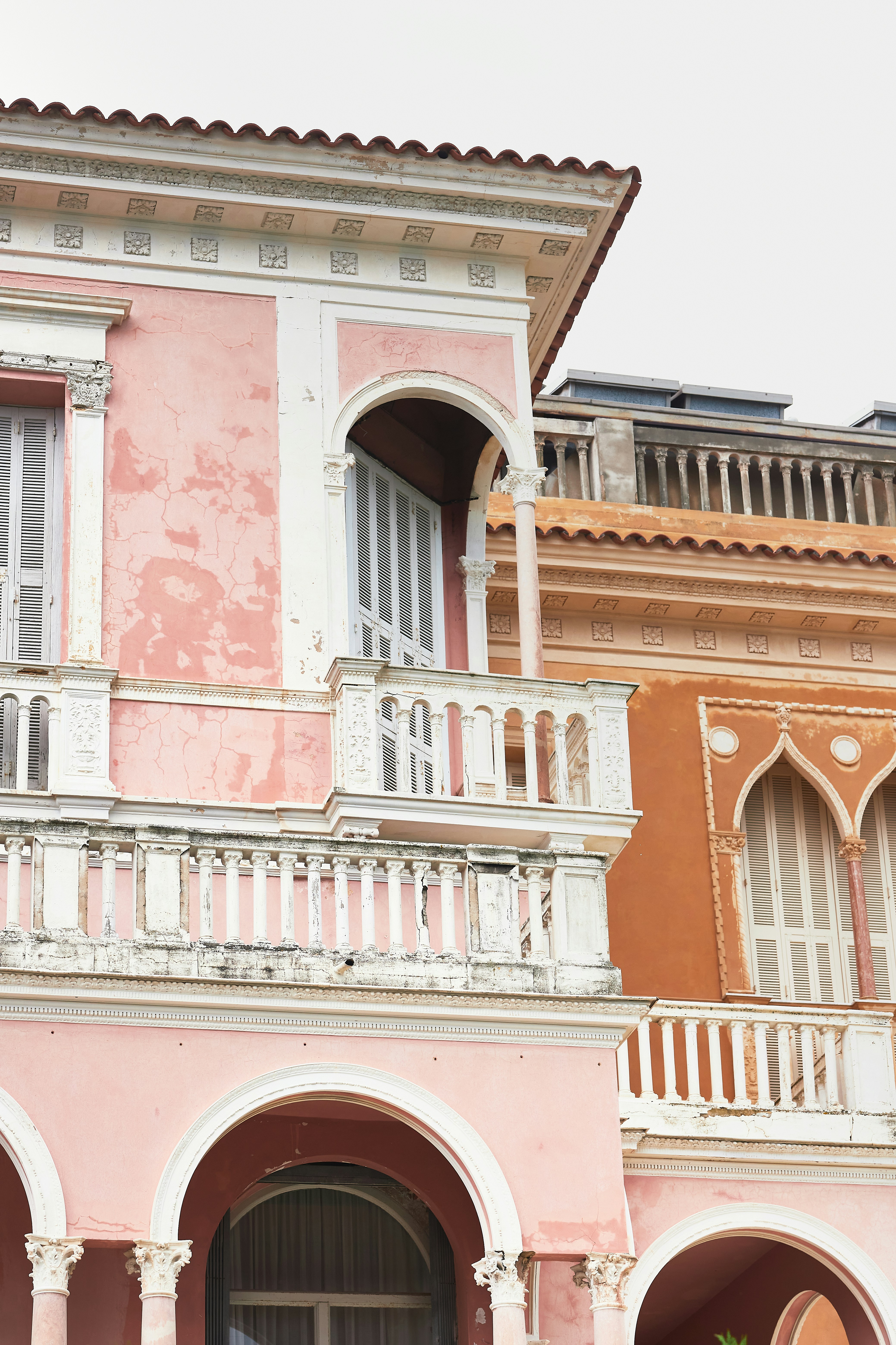 A pink building with a balcony and balconies