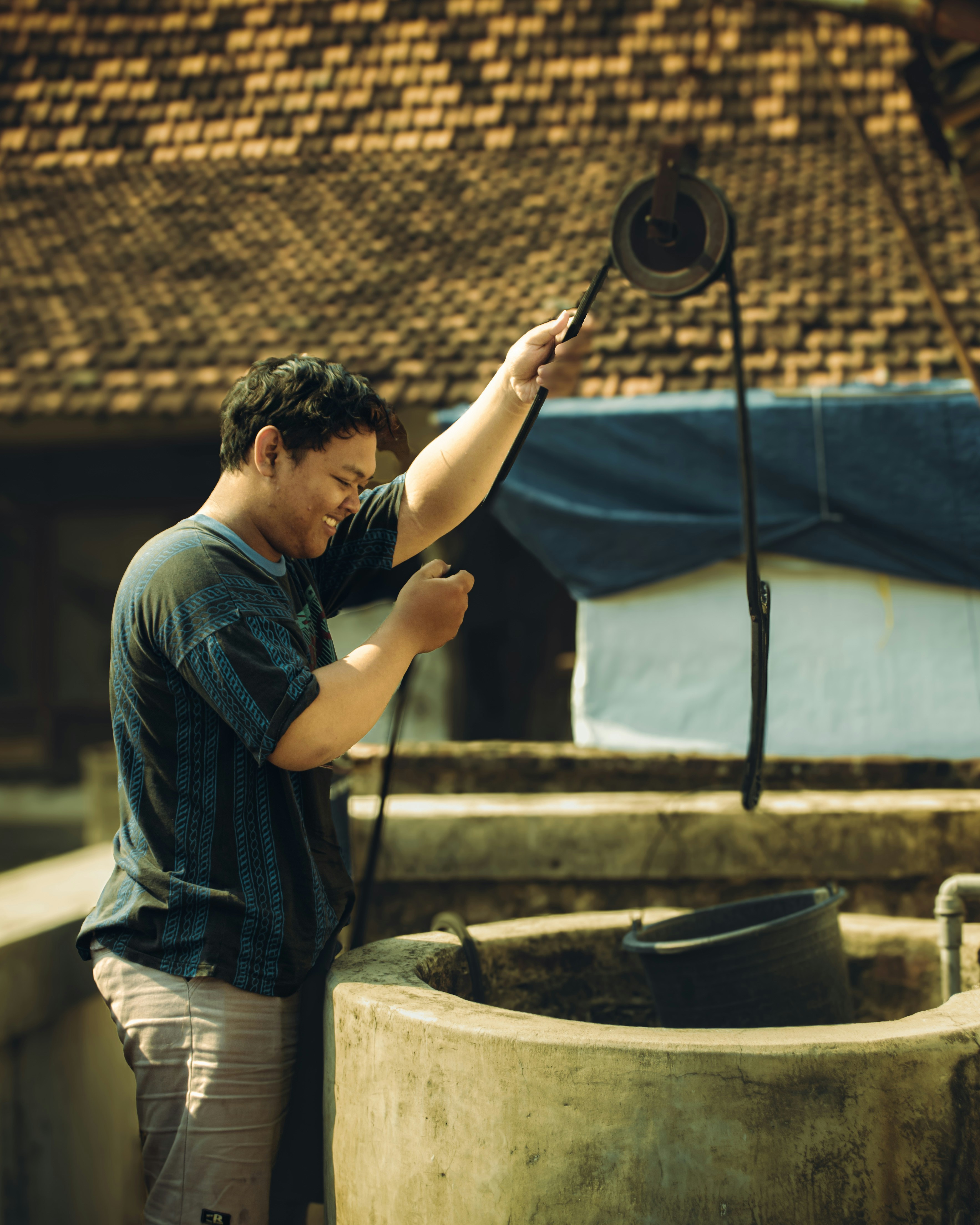 A man standing next to a barrel of water