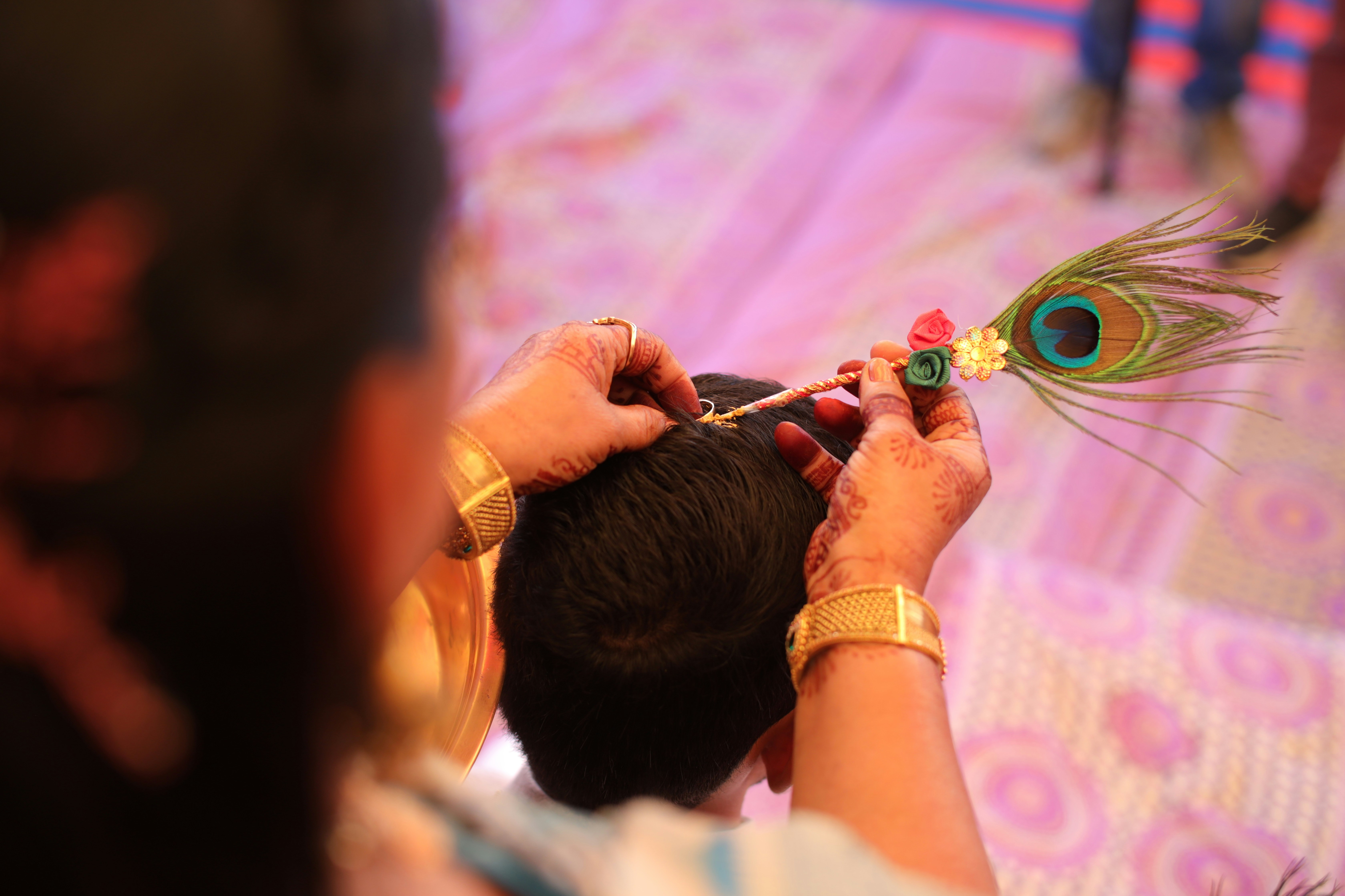 A woman holding a peacock feather in her hand