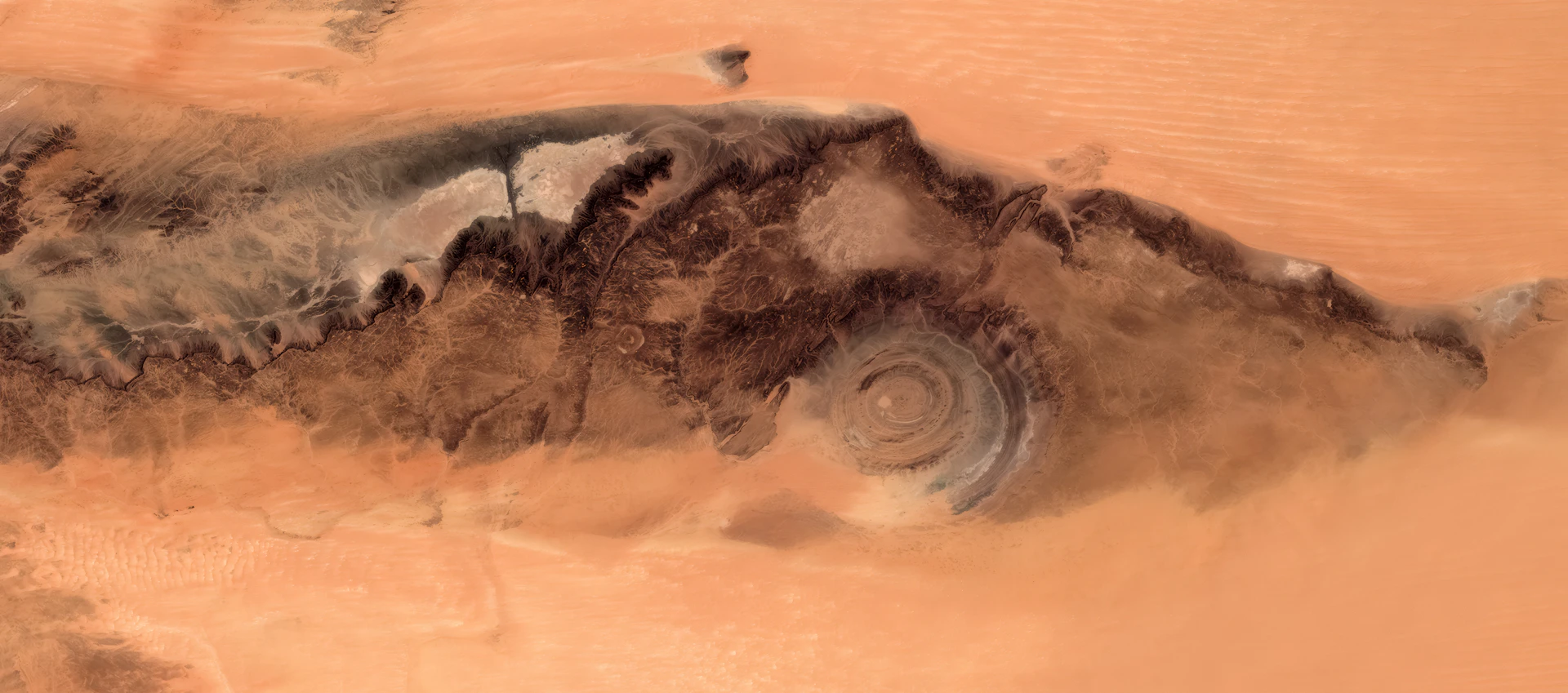 Concentric circles in desert landscape with dust plumes.