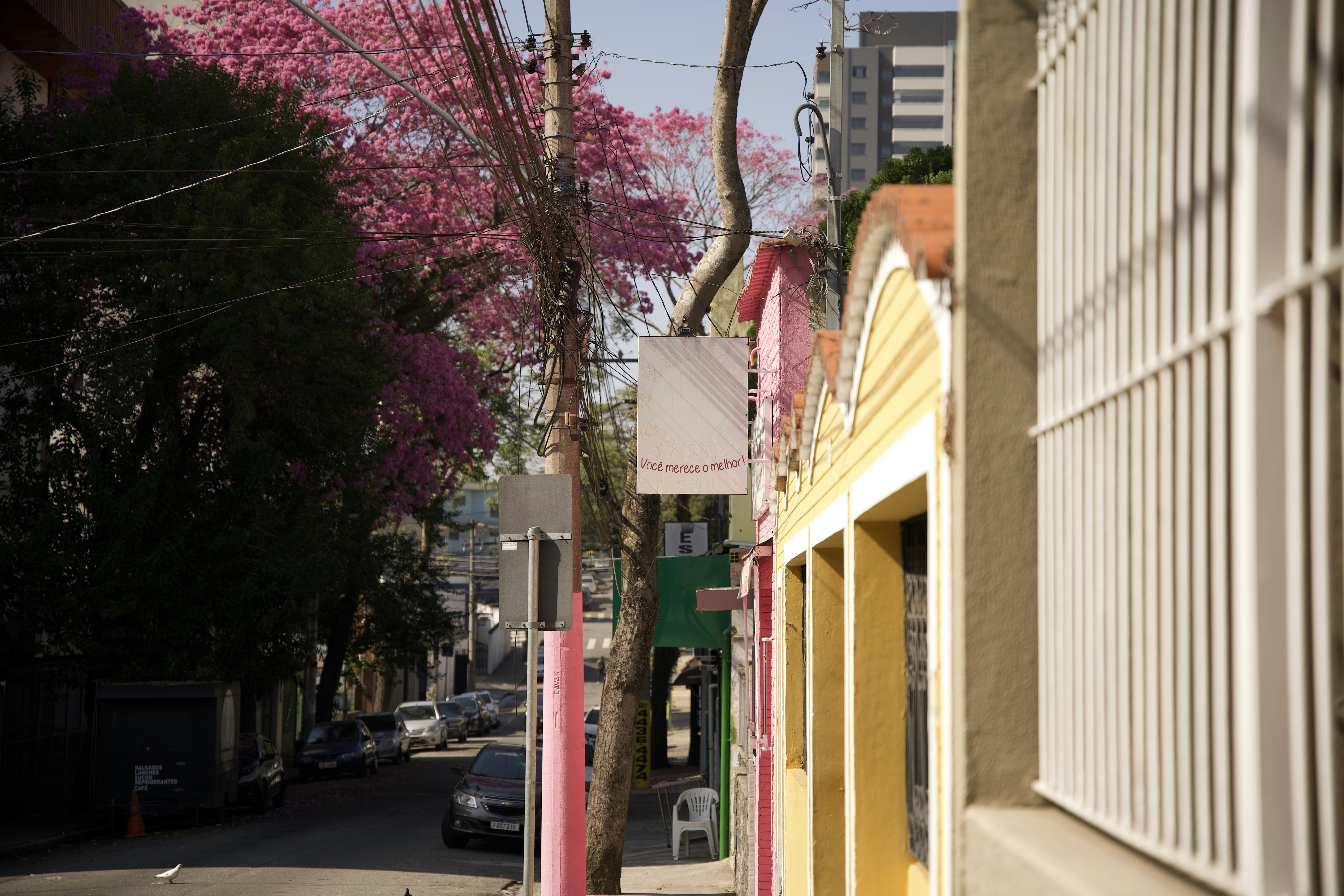 A city street with parked cars and tall buildings