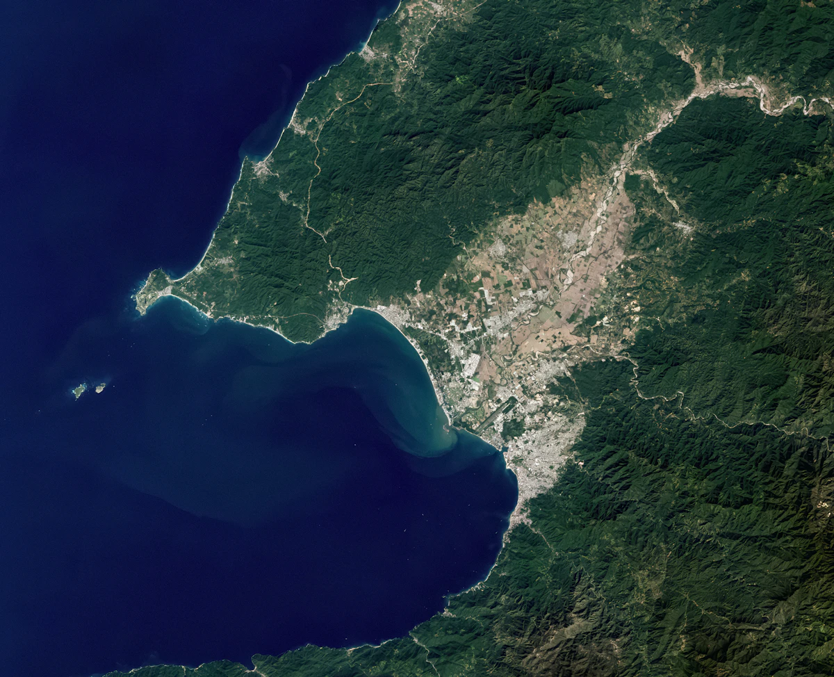 A satellite view of a coastal city beside a bay.