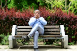 A man sitting on a bench in a park