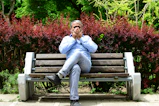 A man sitting on a bench in a park