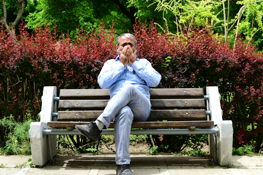 A man sitting on a bench in a park