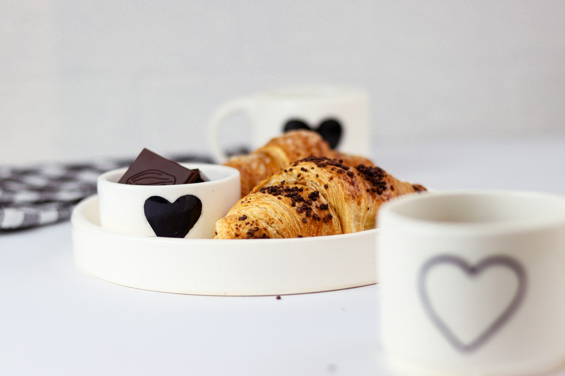 A white plate topped with pastries next to a cup of coffee
