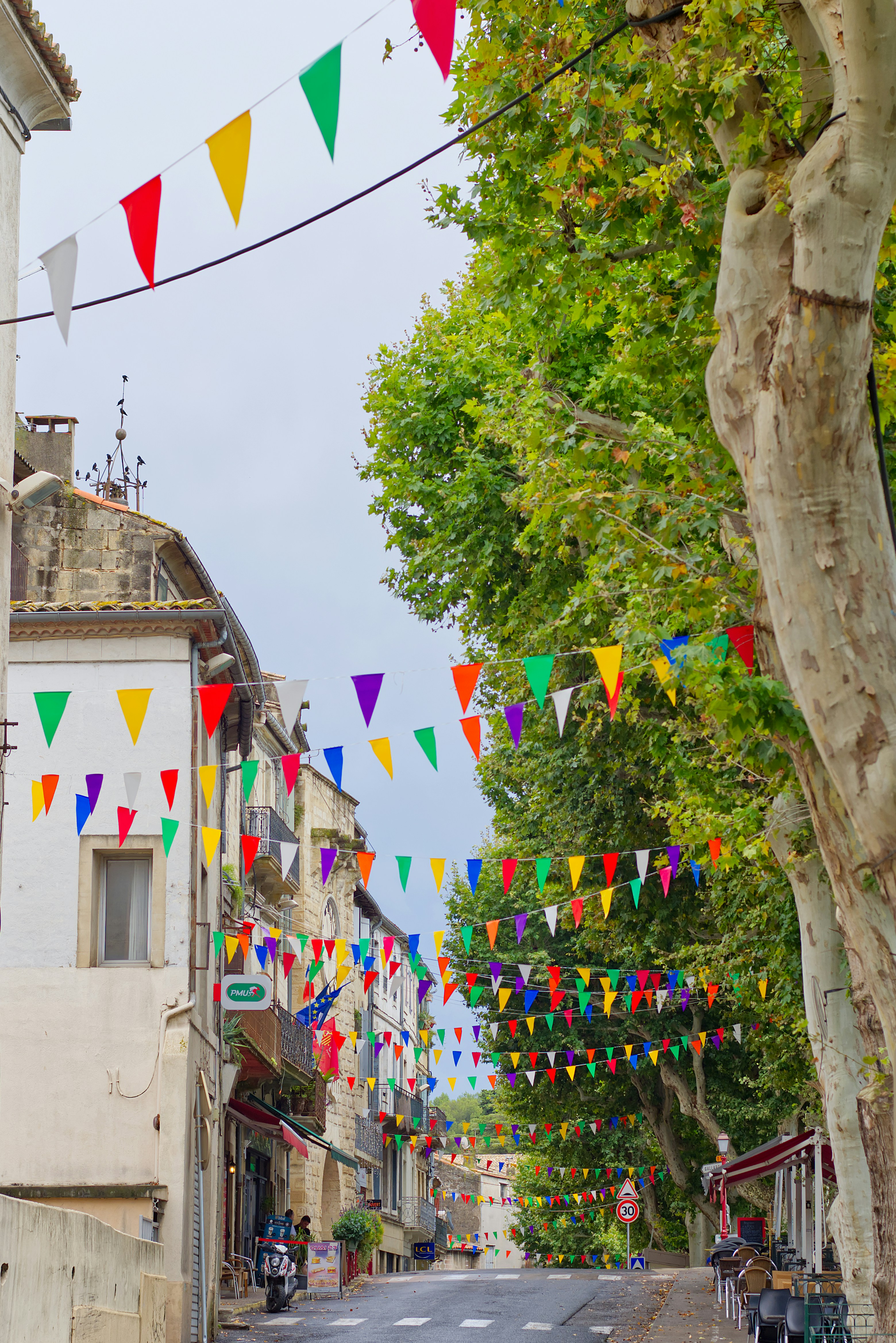 A street lined with buildings and colorful flags