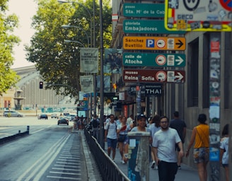 A group of people walking down a street next to tall buildings