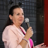A woman in a pink shirt holding a microphone