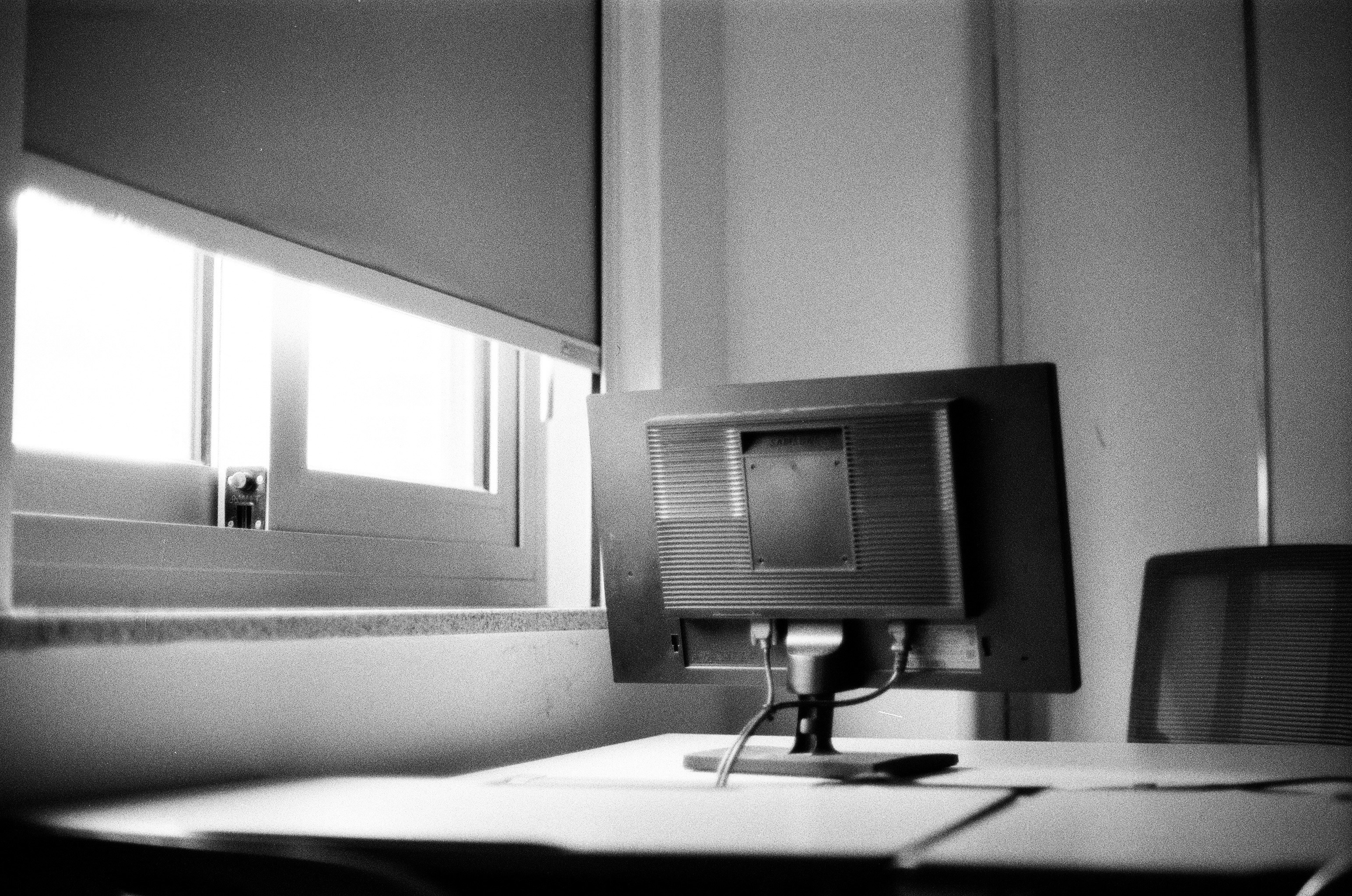 A black and white photo of a desk with a computer