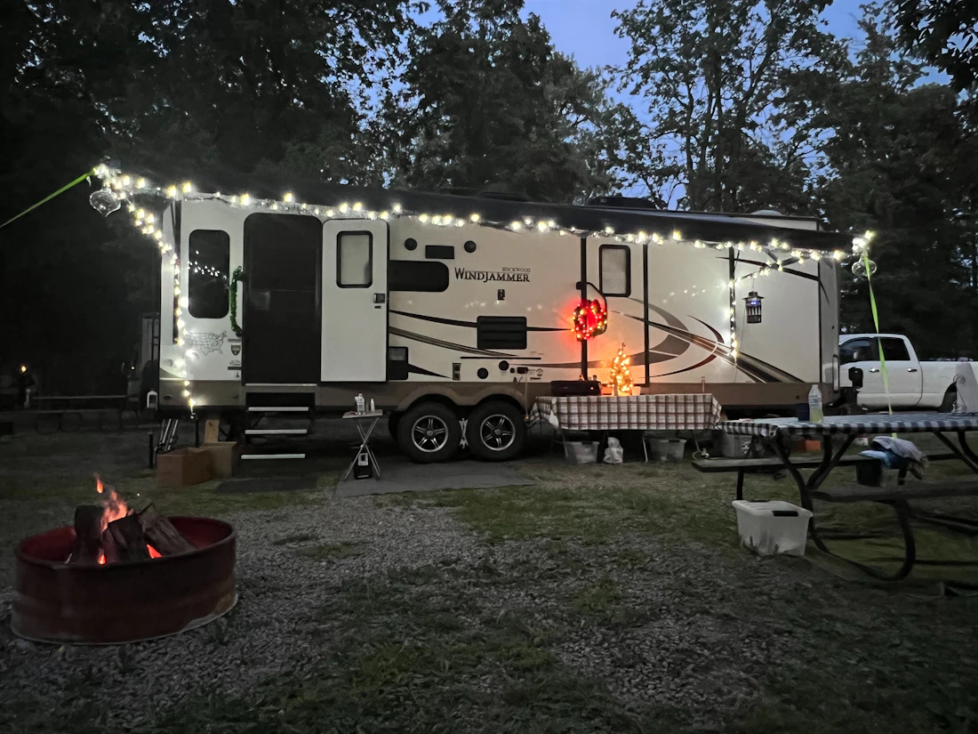 Camper trailer lit up with string lights on a cold evening