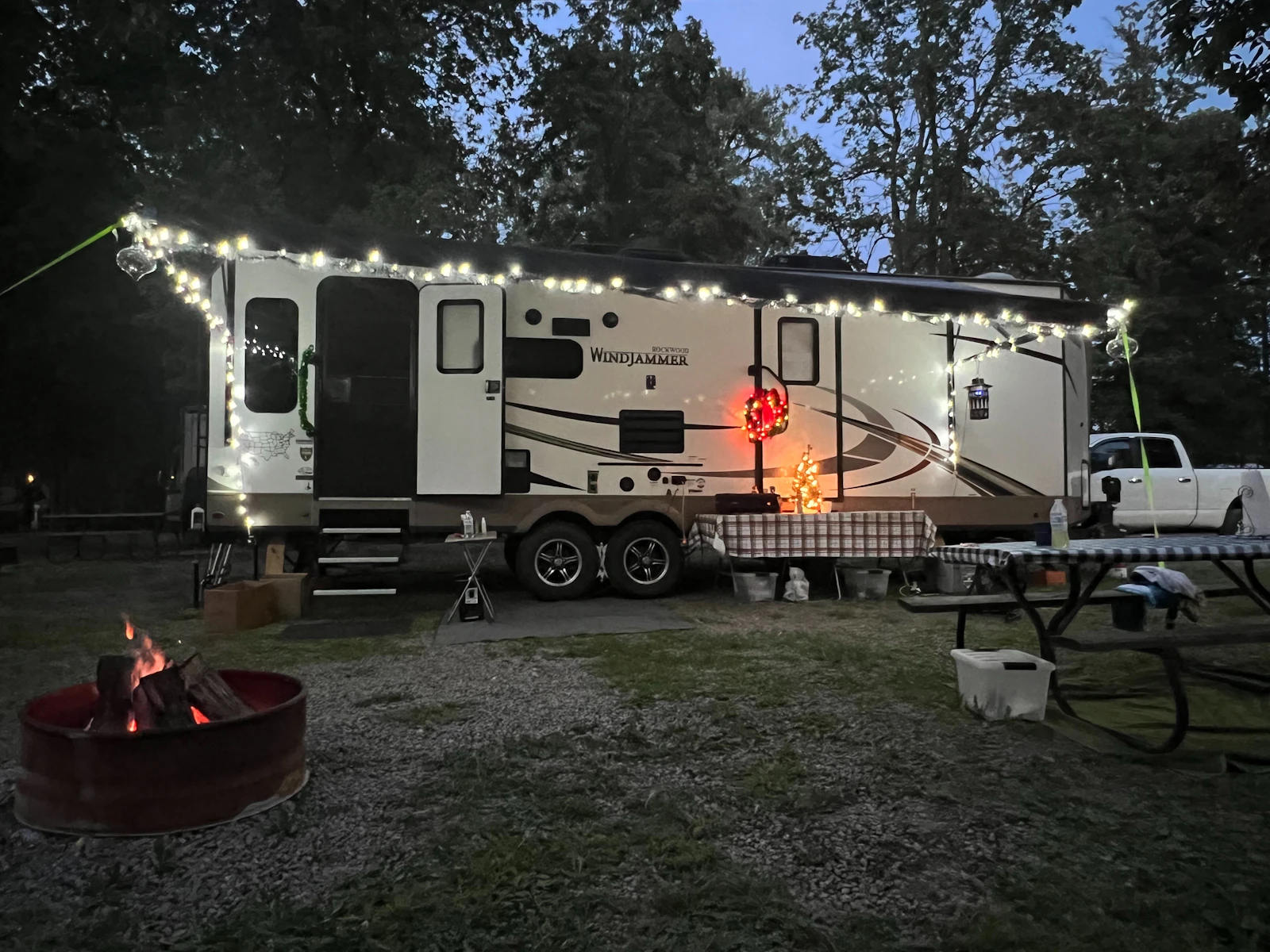 Camper trailer lit up with string lights on a cold evening