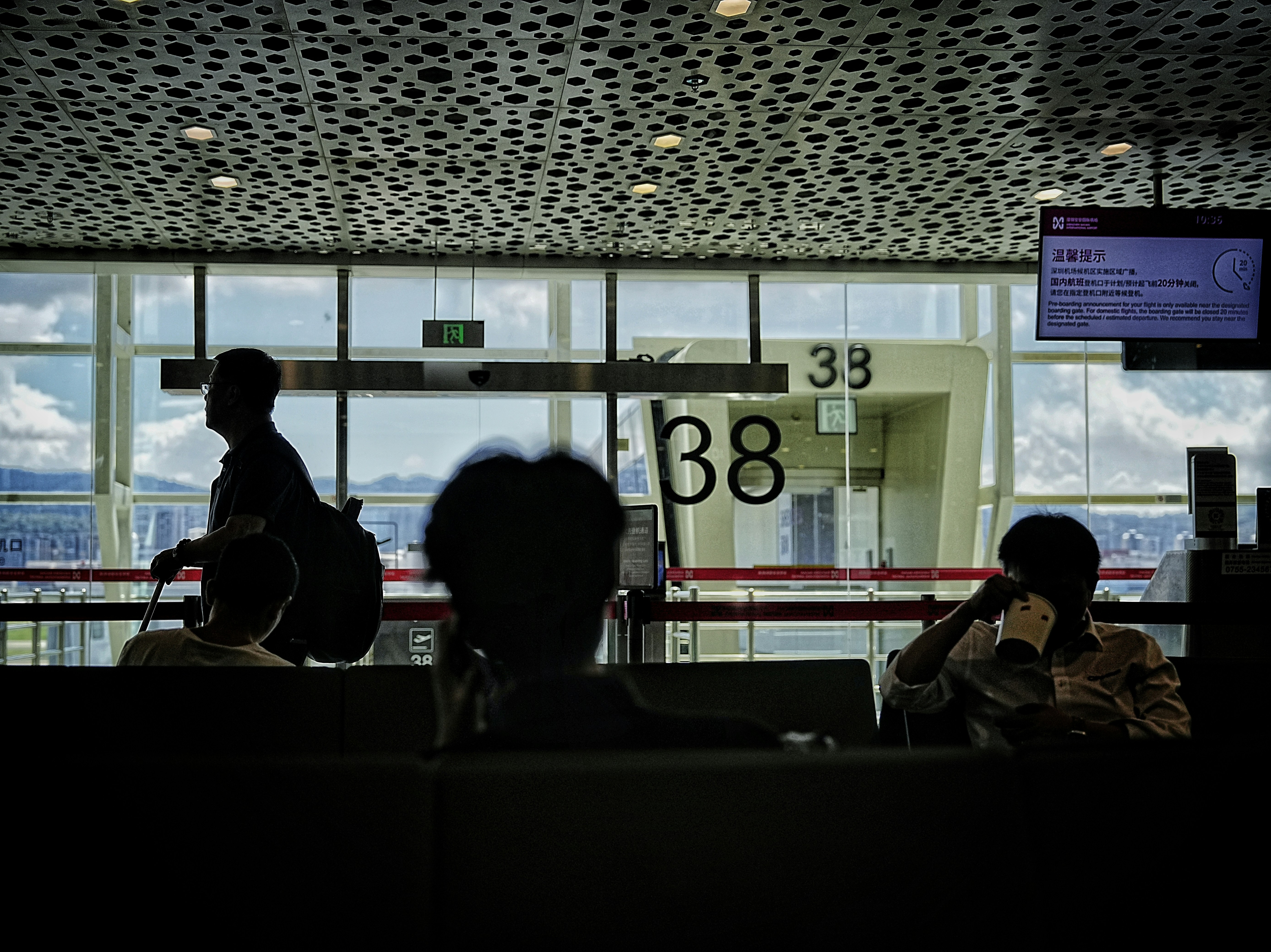 A group of people sitting in front of a window, 