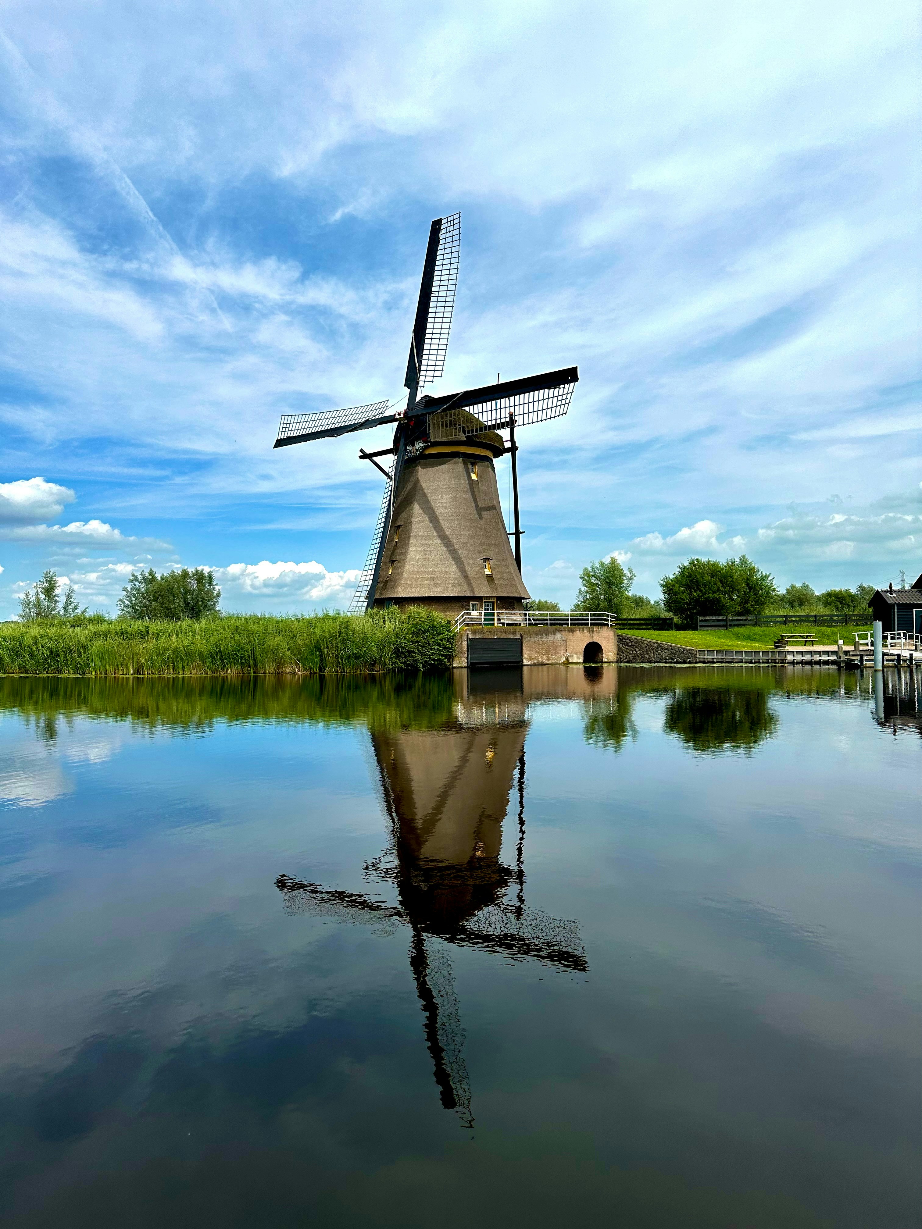 A windmill sitting on top of a lake next to a dock