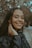 A young woman with braids smiling at the camera