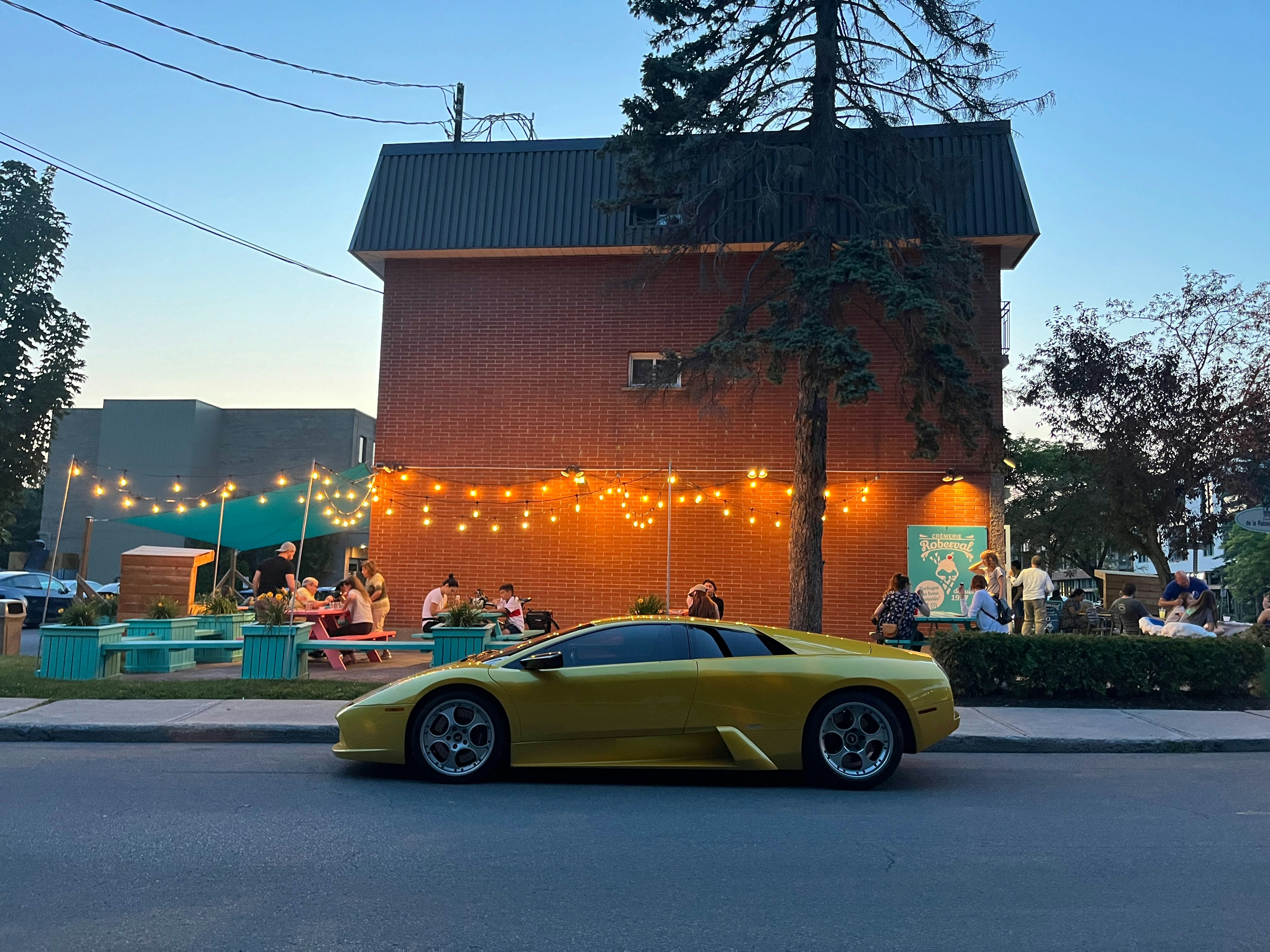 A yellow sports car parked in front of a building