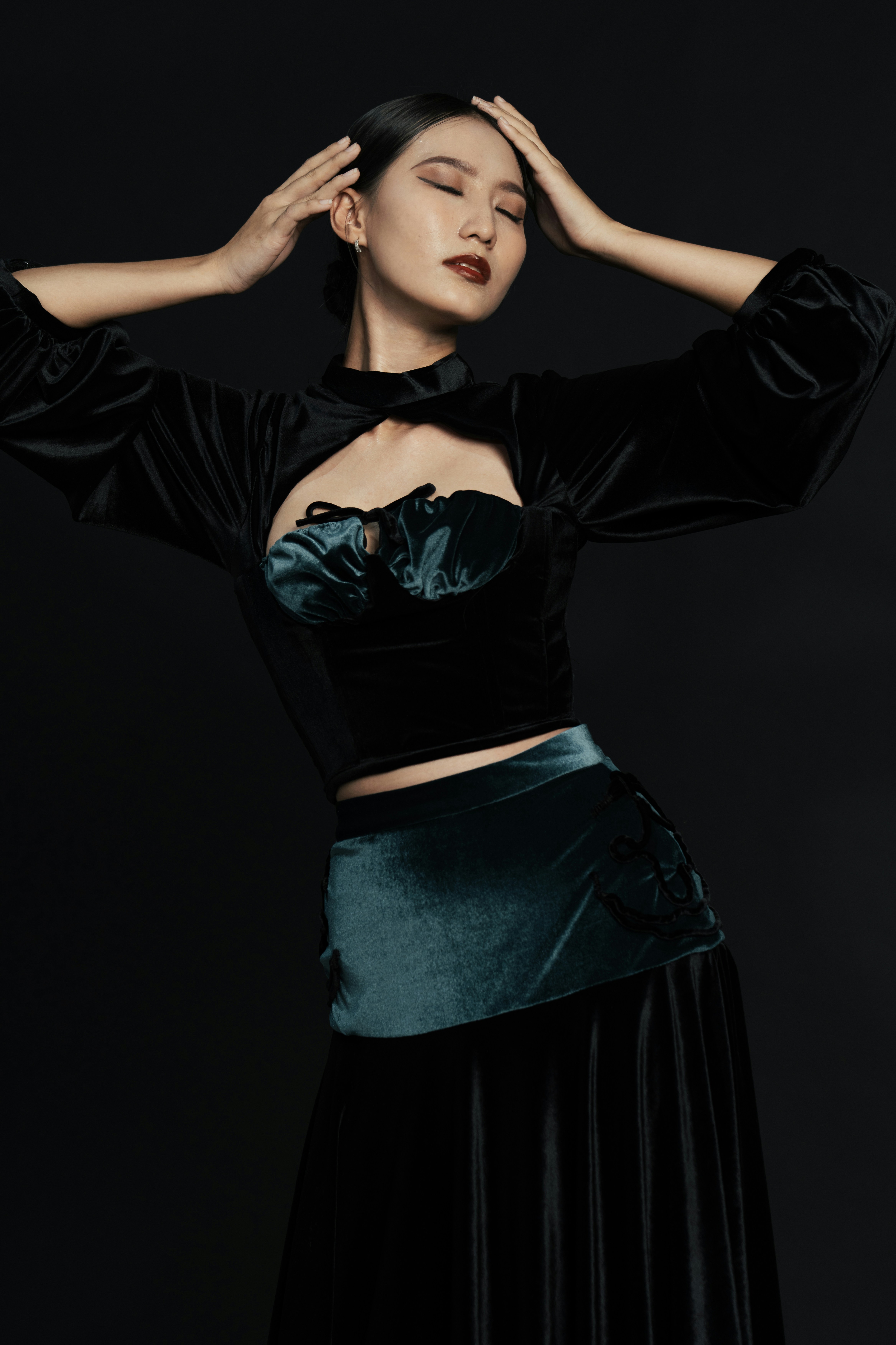 A woman in a black top and green skirt