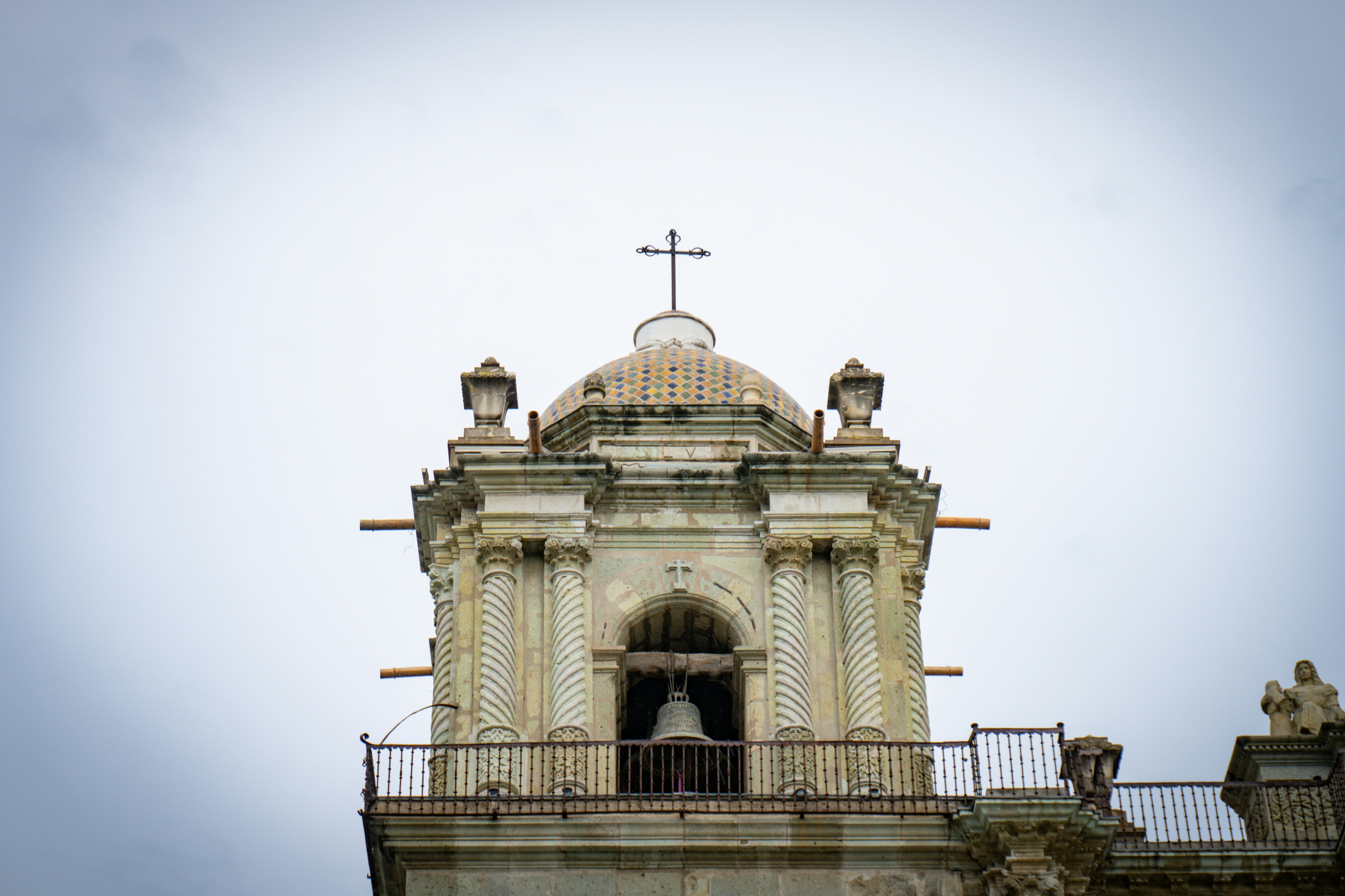 A clock tower with a cross on top of it