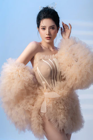 A woman in a feathered dress posing for a picture