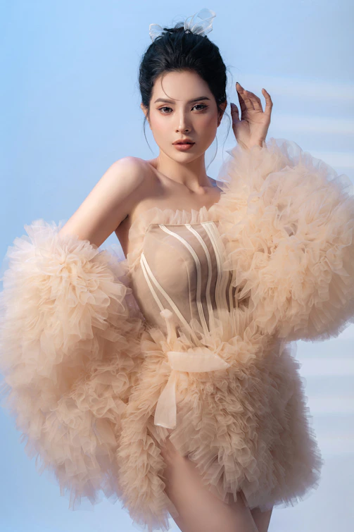 A woman in a feathered dress posing for a picture