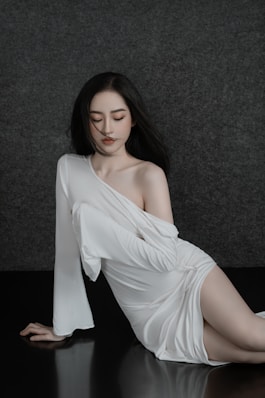 A woman in a white dress sitting on a table