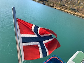 A flag flying from a boat in a body of water