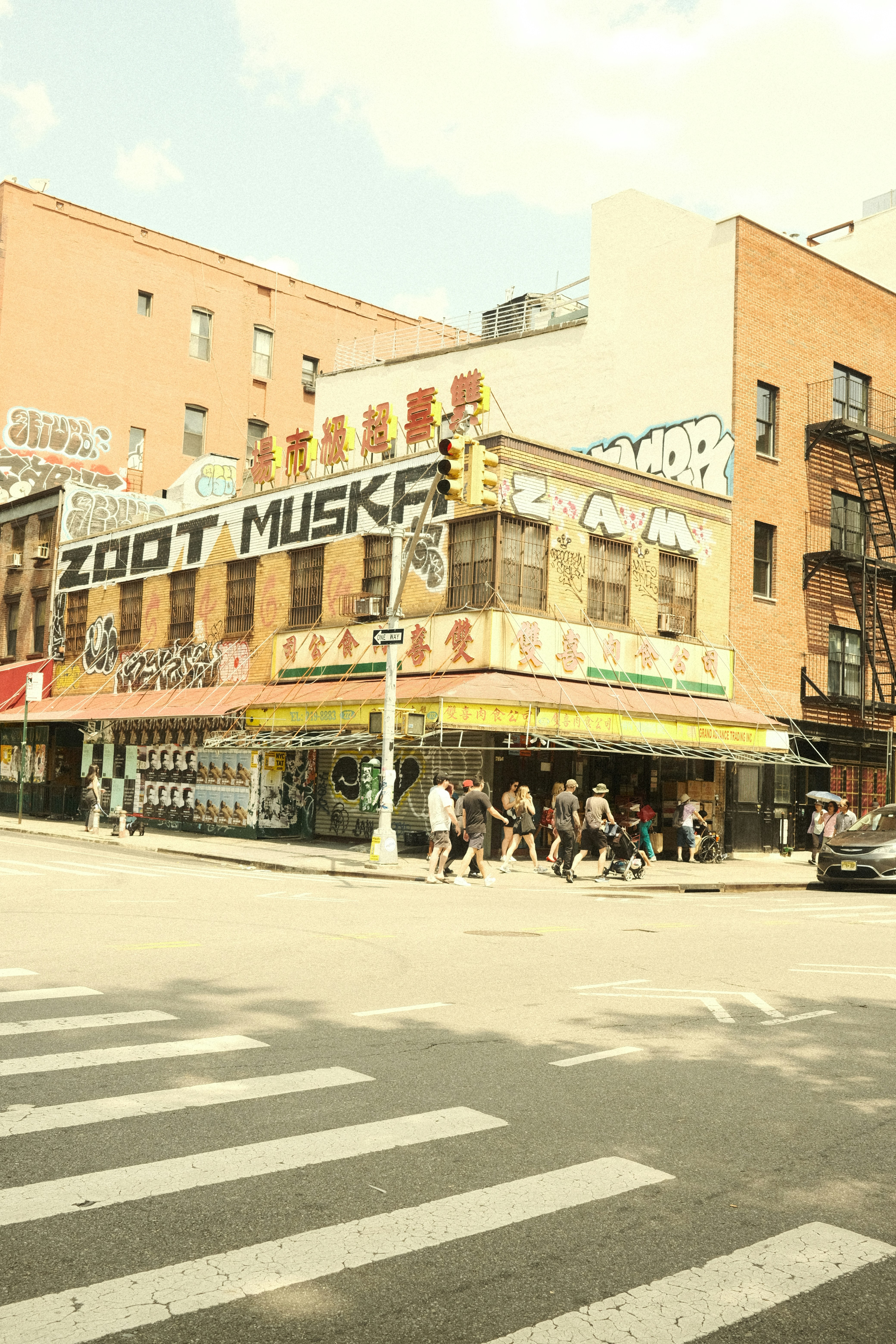 A group of people walking across a street next to tall buildings photo ...