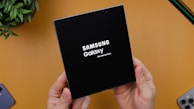 A person holding a black box with the samsung logo on it
