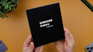 A person holding a black box with the samsung logo on it