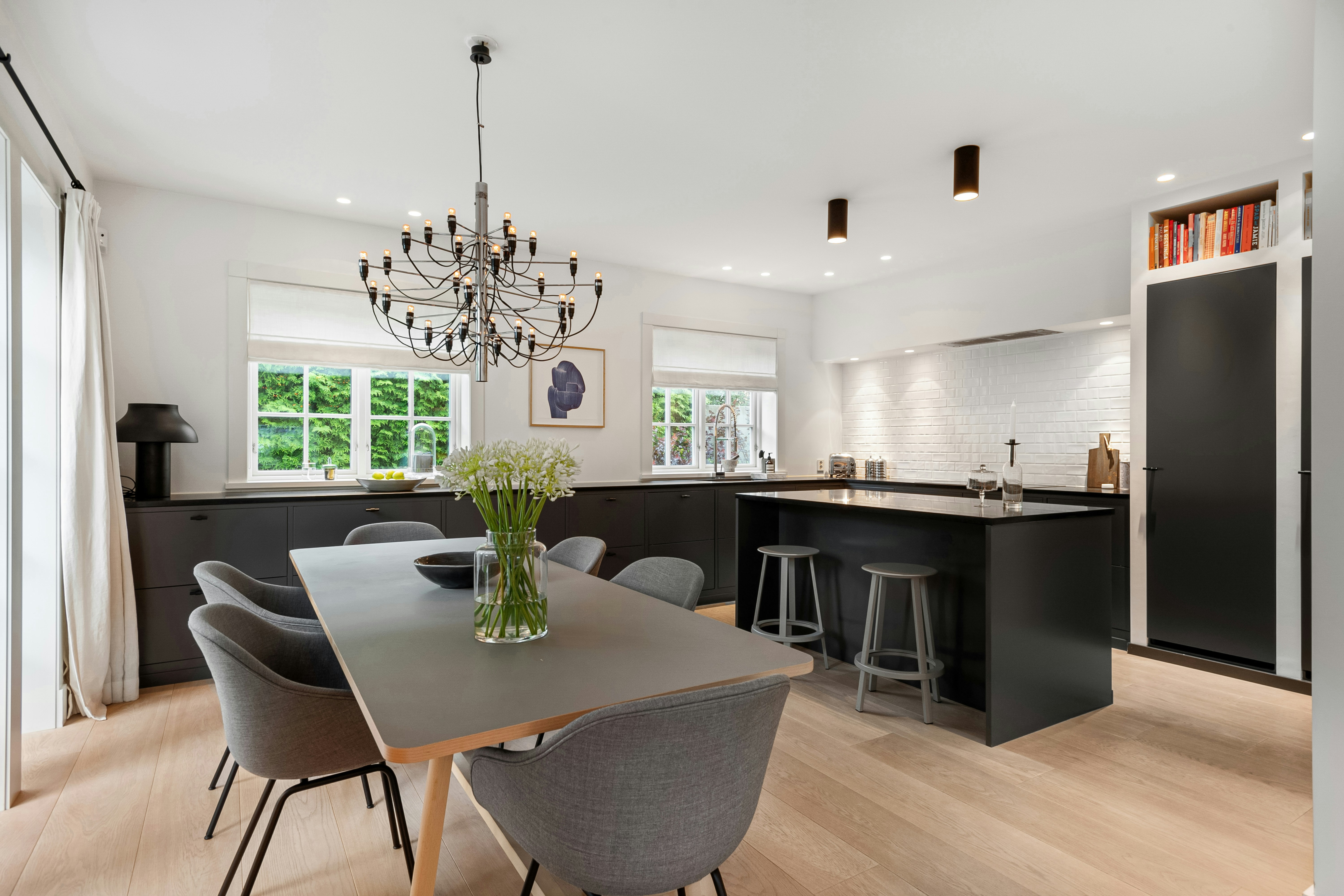 A dining room table with chairs and a chandelier