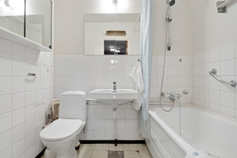 A white bathroom with a tub, toilet and sink