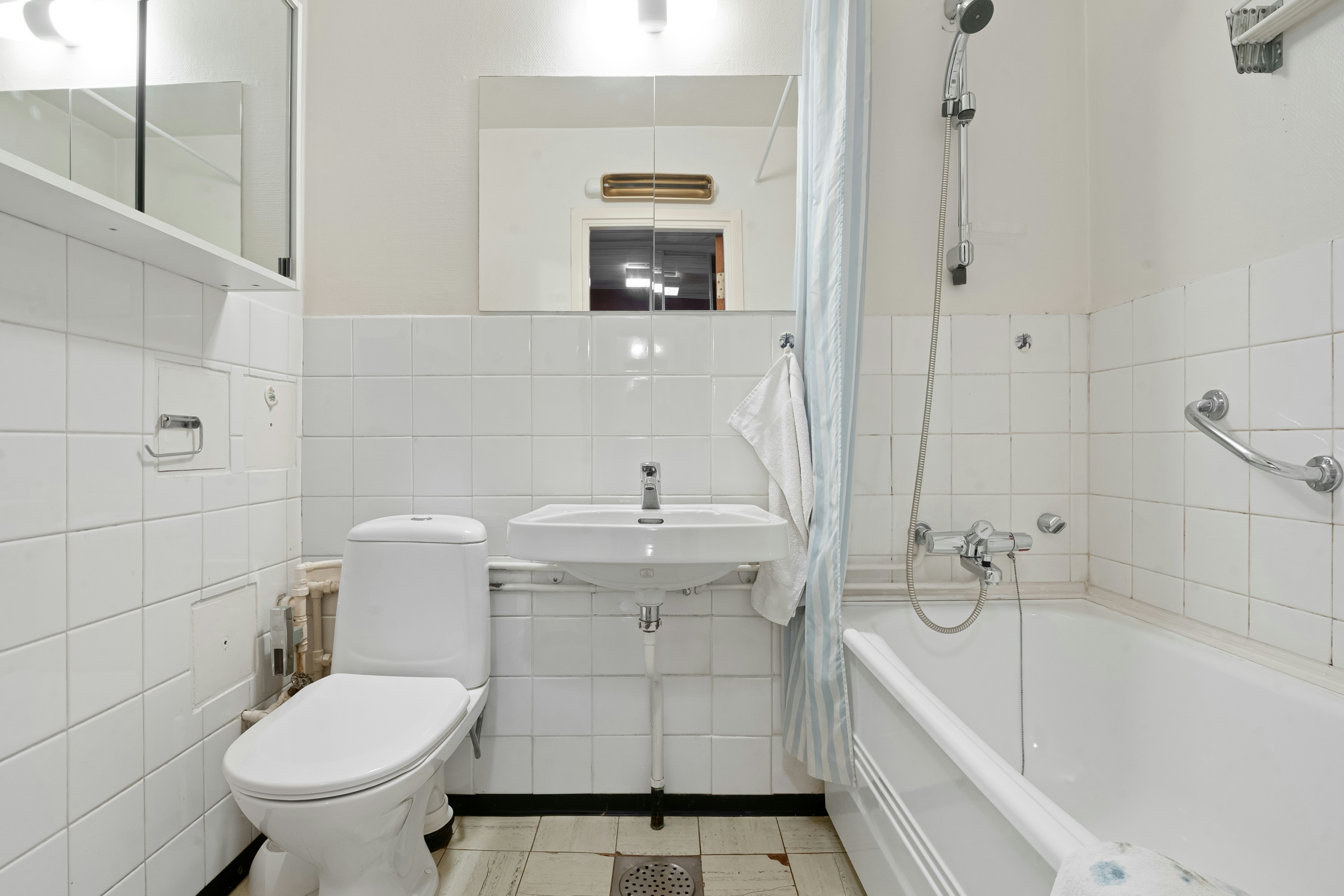 A white bathroom with a tub, toilet and sink