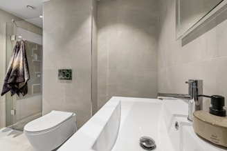 A bathroom with a toilet, sink, and mirror