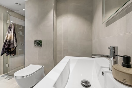 A bathroom with a toilet, sink, and mirror