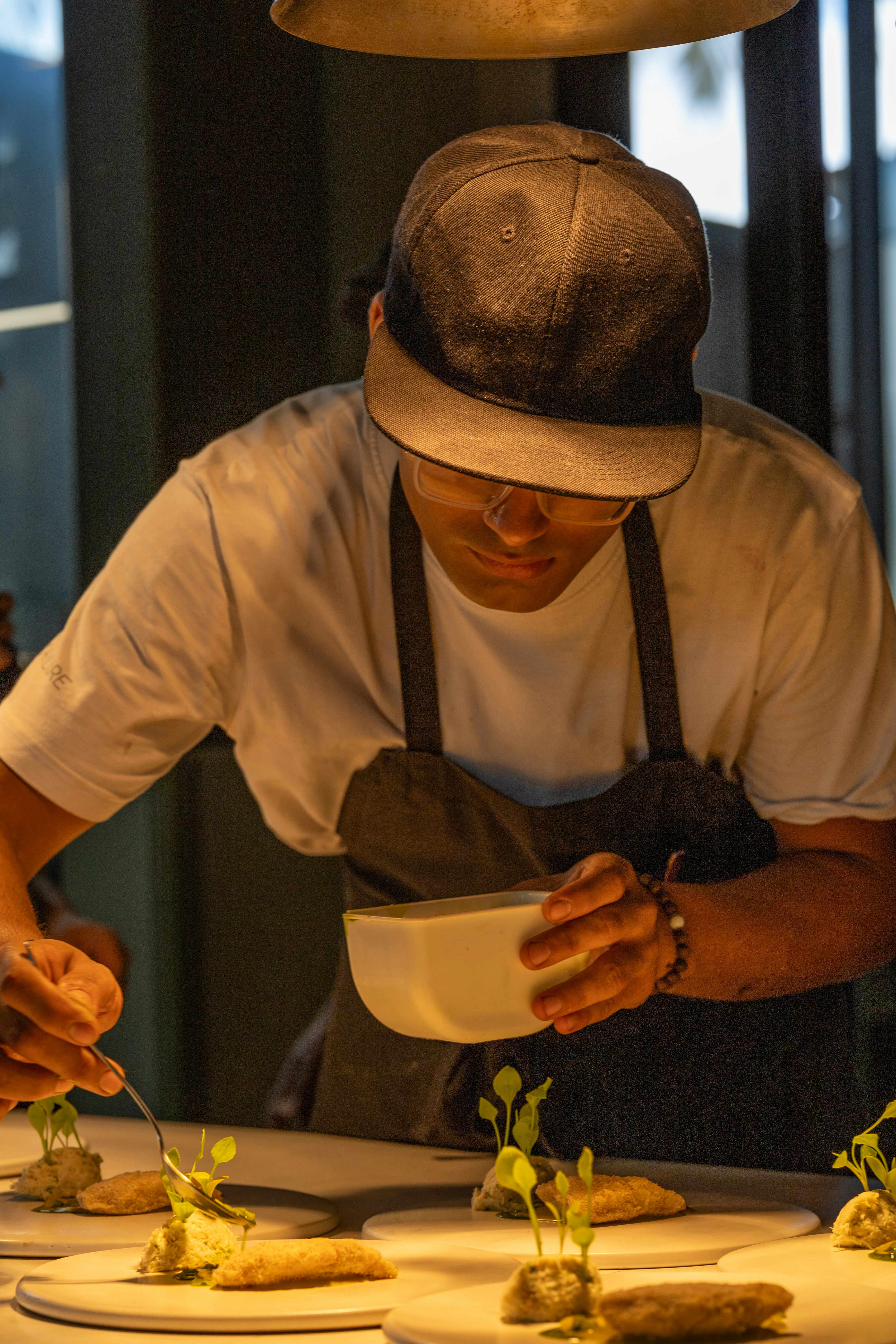 A man in a hat is preparing food on a table