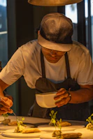 A man in a hat is preparing food on a table