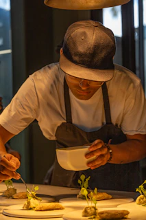 A man in a hat is preparing food on a table