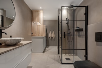 A bathroom with a sink, mirror, toilet and shower